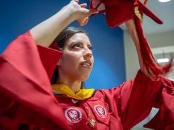 Andrea Uguna-Solano puts on her mortarboard.